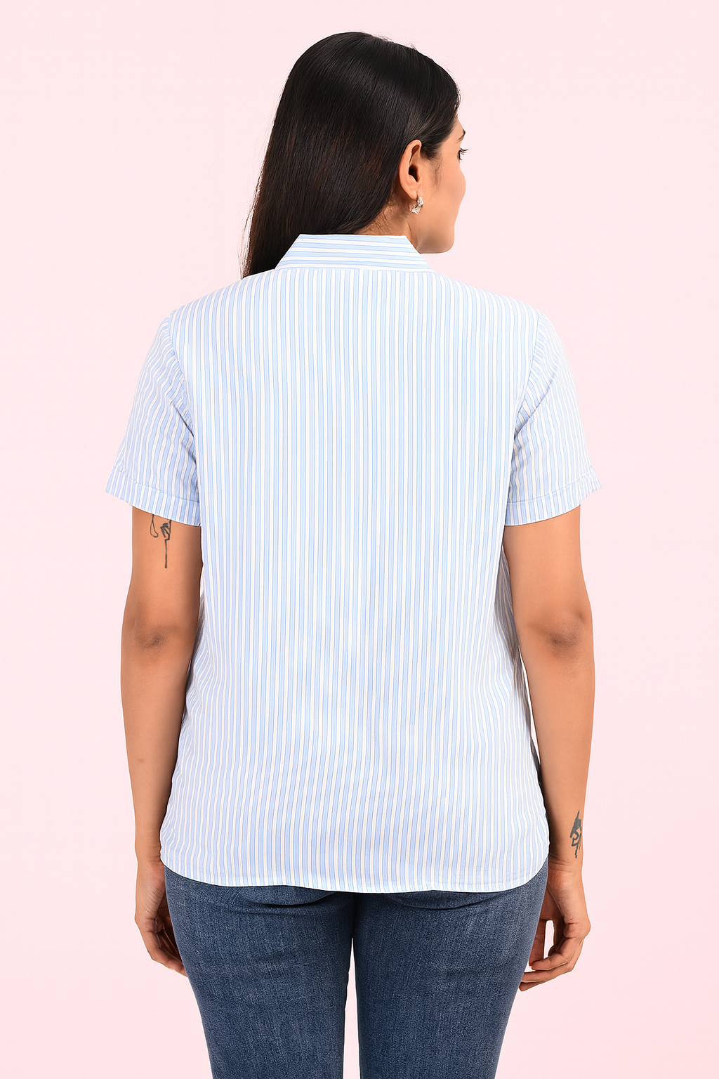 “Back view of woman wearing light blue striped shirt and blue jeans – showcasing shirt design and fit by Classy Clothing.”