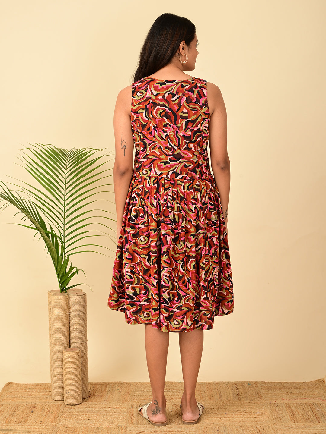 Back view of a multicolor all-over printed rayon midi dress for women in India featuring a sleeveless design, fit and flare silhouette, soft breathable fabric, and elegant back fit.