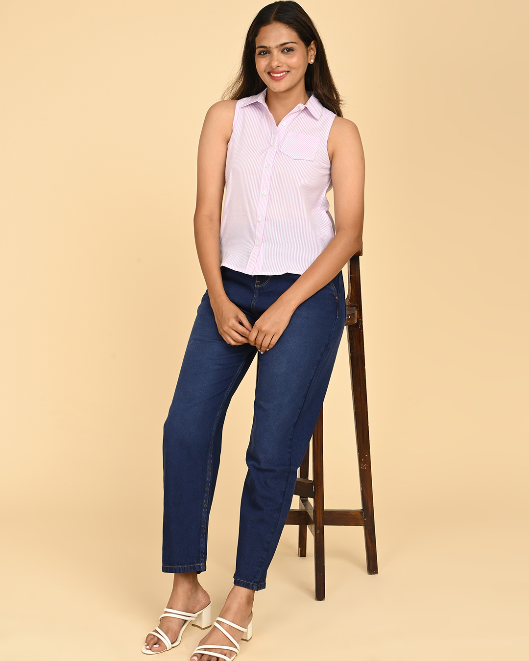 Woman wearing lilac striped sleeveless cotton shirt for women with blue jeans