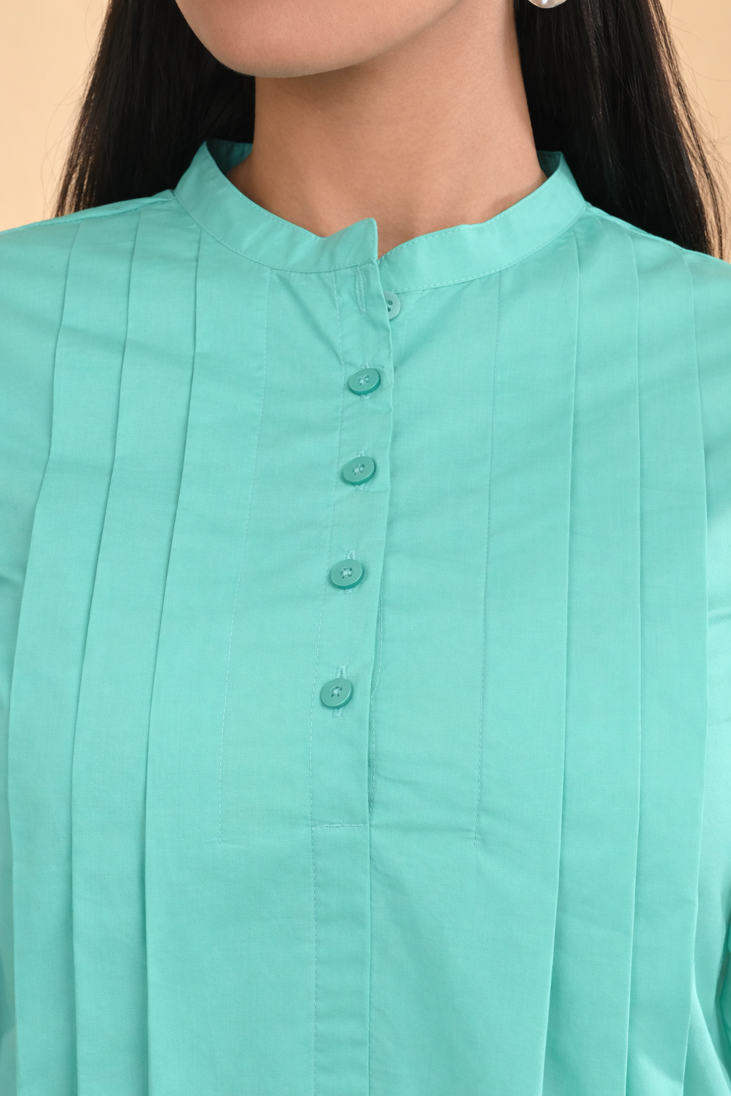 Close-up of mint green pleated cotton office wear top for women with band collar and button placket