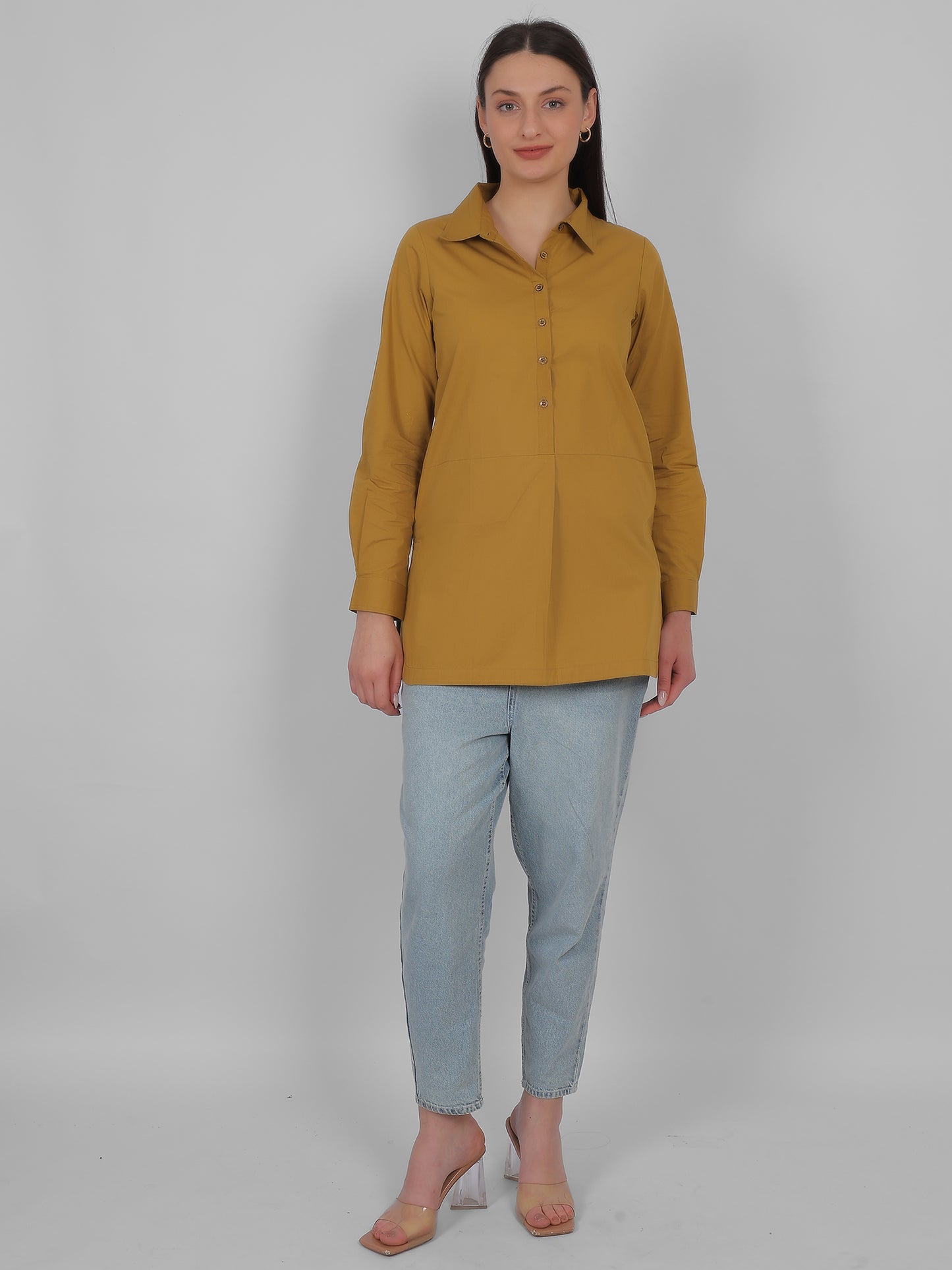 Full body front view of mustard yellow 100% cotton solid long top for women styled with jeans showing straight fit and elegant casual look for everyday wear in India