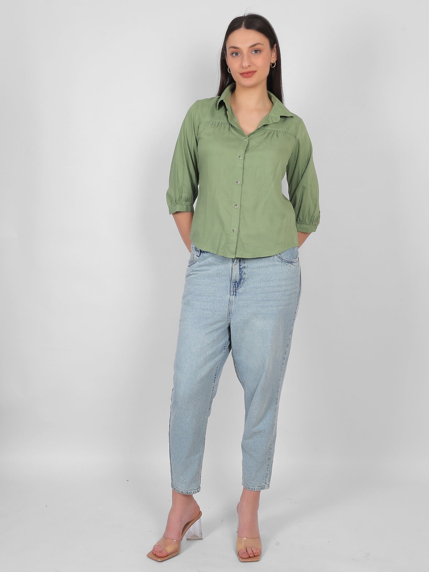 Solid green 100% rayon top for women styled with jeans, full length front view showing collared neckline, front buttons and three quarter sleeves, casual and office wear outfit for Indian women