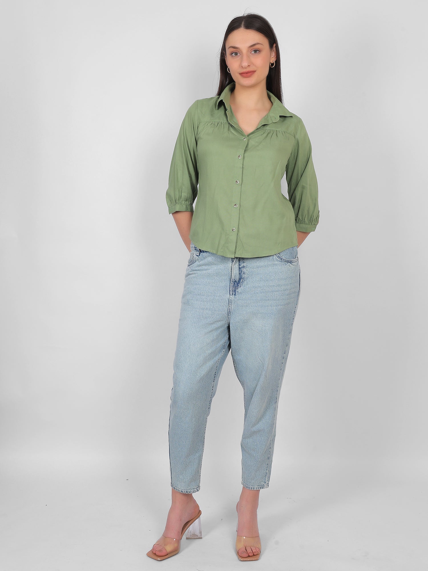 Solid green 100% rayon top for women styled with jeans, full length front view showing collared neckline, front buttons and three quarter sleeves, casual and office wear outfit for Indian women