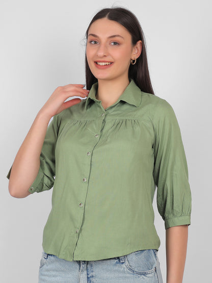 Solid green 100% rayon top for women shown from side angle with collared neck, front buttons and three quarter sleeves, stylish casual and office wear top for Indian women