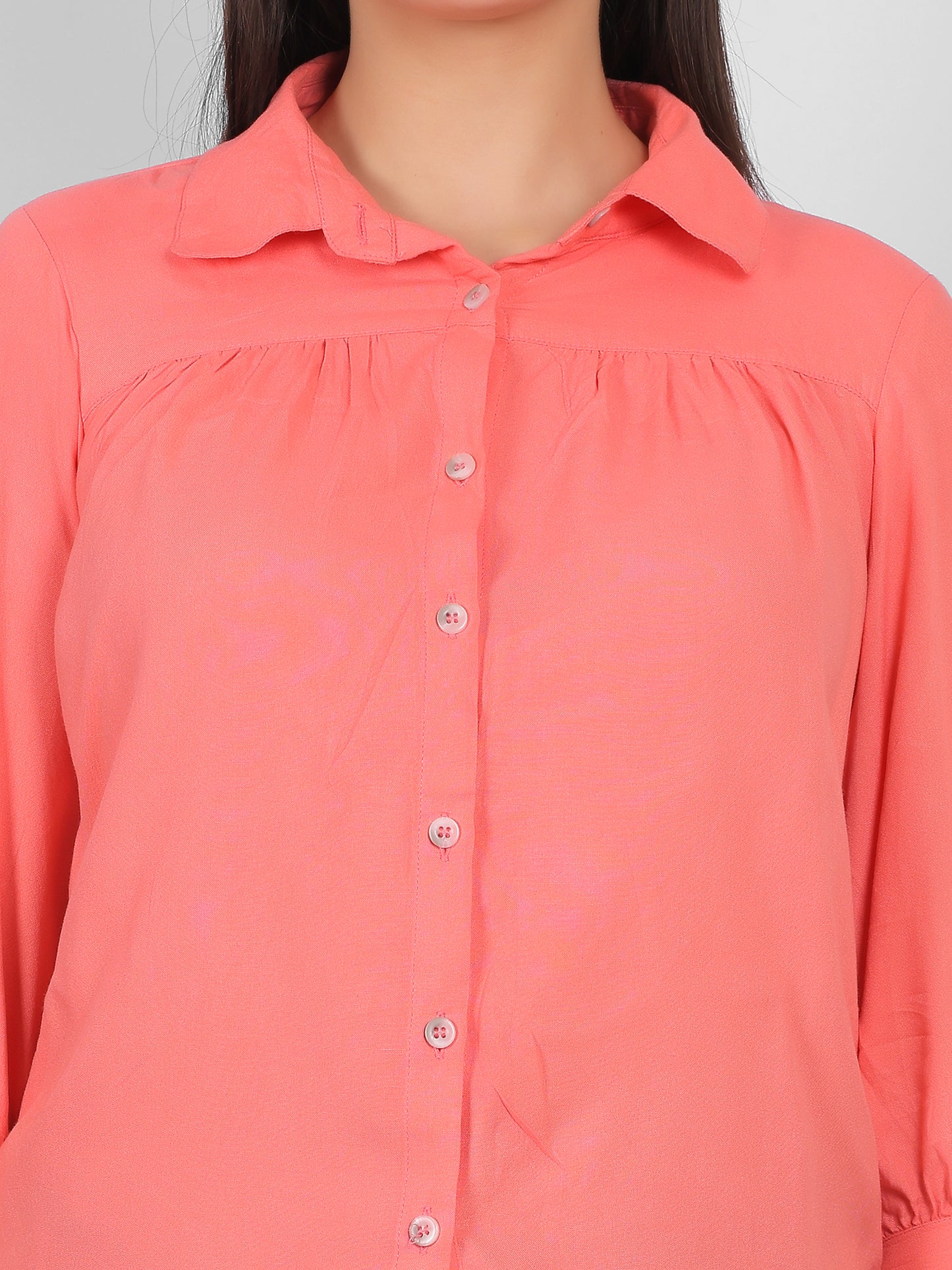 Close up view of solid coral pink 100% rayon top for women showing collared neckline, front button placket and gathered yoke detail, premium casual and office wear top for Indian women
