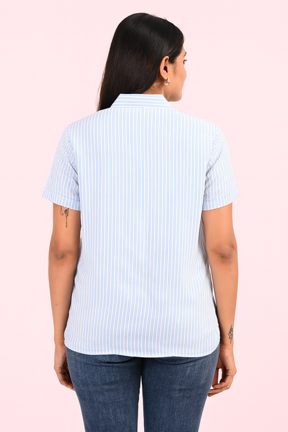 “Back view of woman wearing light blue striped shirt and blue jeans – showcasing shirt design and fit by Classy Clothing.”