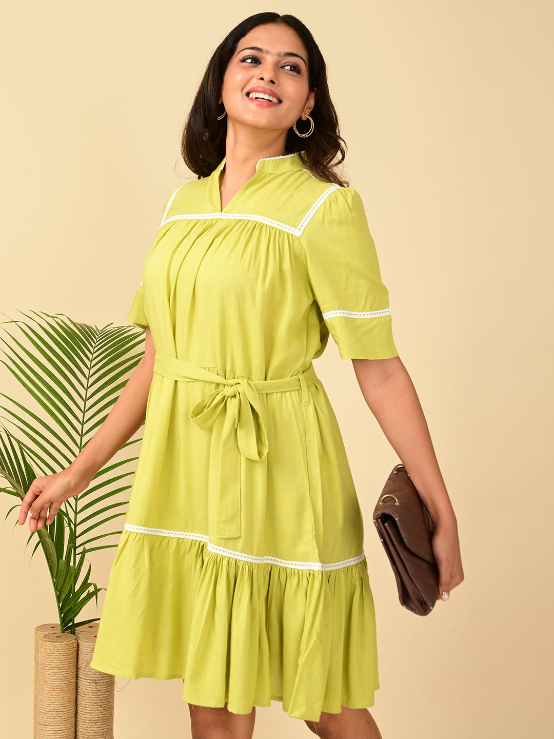 Close-up of a lime green rayon midi dress for women with white lace detailing, waist belt and gathered hem – stylish casual summer dress in India