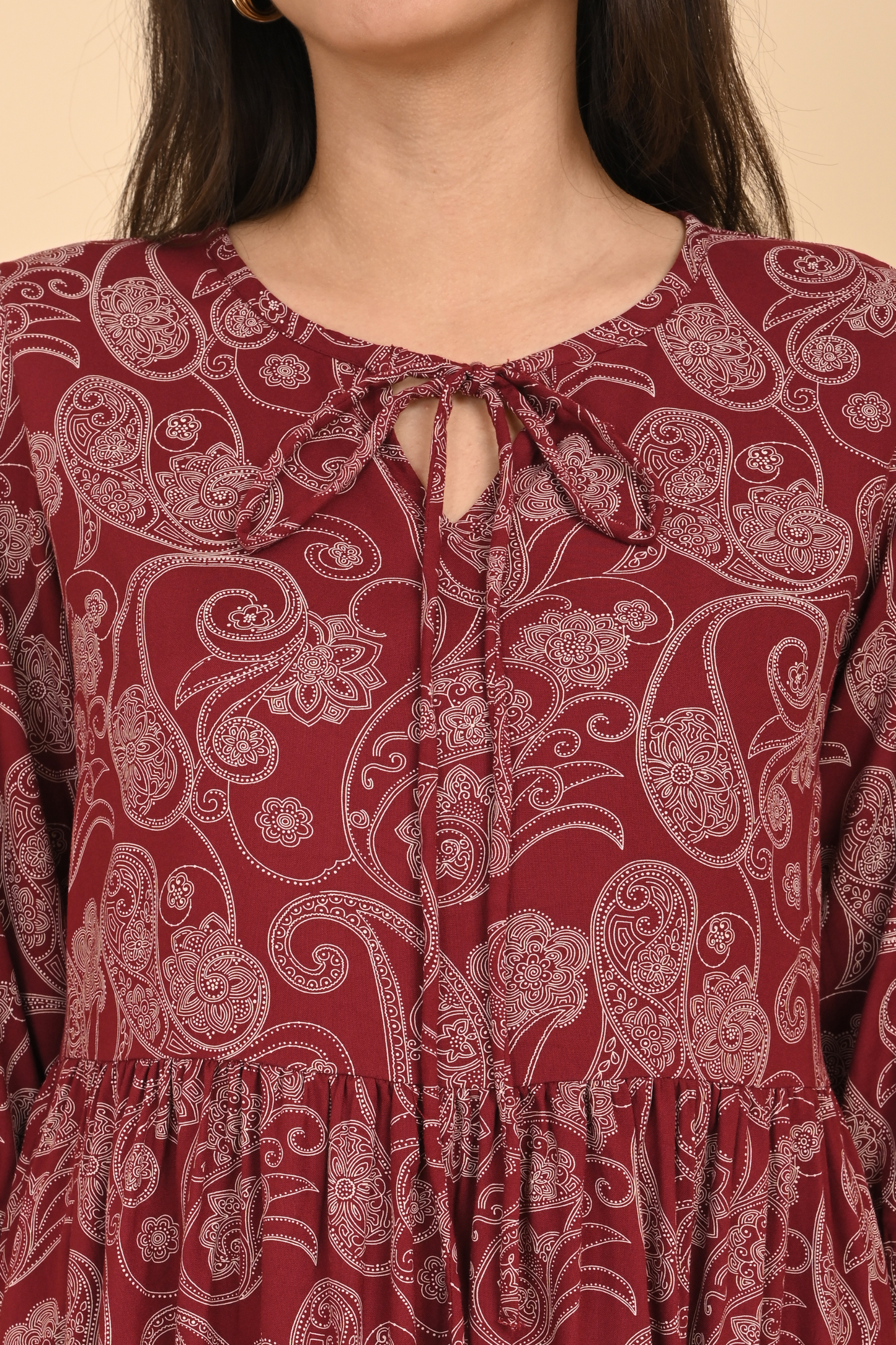 Detail of the neck line and delicate stitching on the maroon paisley print rayon tunic.