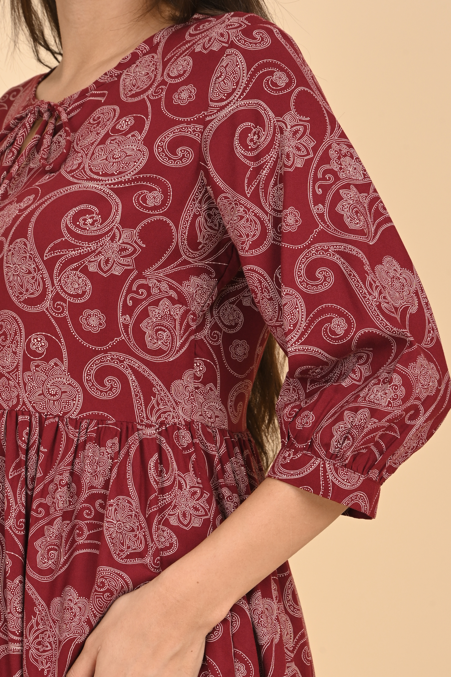 Detail of the sleeve and delicate stitching on the maroon paisley print rayon tunic.