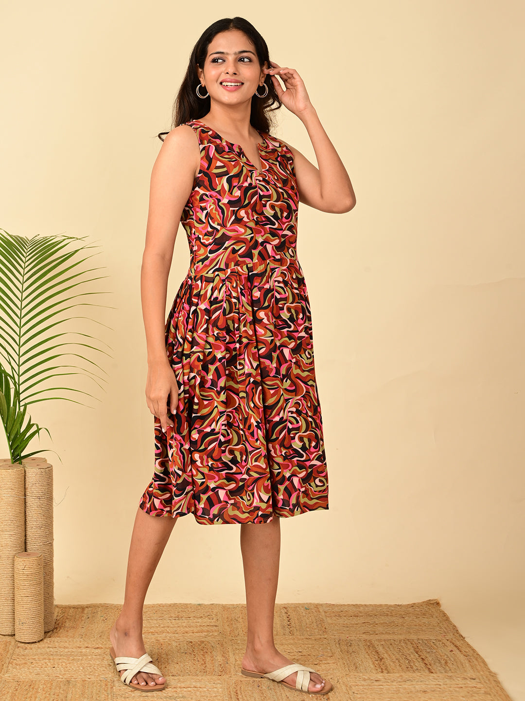 Side view of a multicolor all-over printed rayon midi dress for women in India with sleeveless design, fit and flare silhouette, soft breathable fabric, and comfortable casual wear.